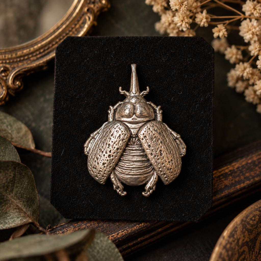 Broche insecte scarabée Création MOUNS portée sur un manteau noir