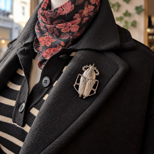 Broche scarabée Création MOUNS portée sur un manteau noir