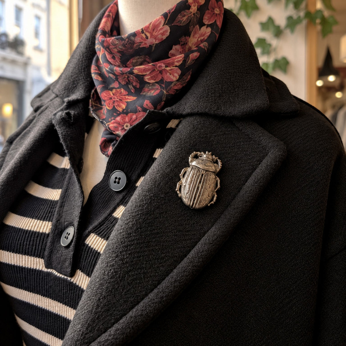 Broche scarabée Création MOUNS portée sur un manteau noir